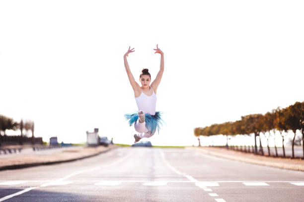 Beautiful ballet dancer posing at street