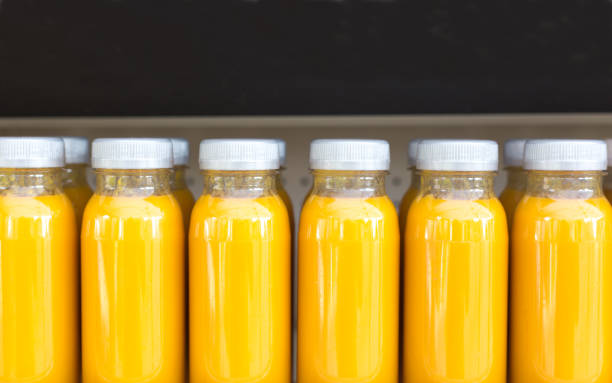 istock Bottles of Fresh-Pressed Fruit Juice Lined Up: OJ/Mango/Peach 1157873092