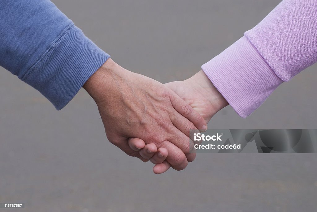 Two women, mother and daughter holding hands Mother and daughter, holding hands at the beach 20-24 Years Stock Photo