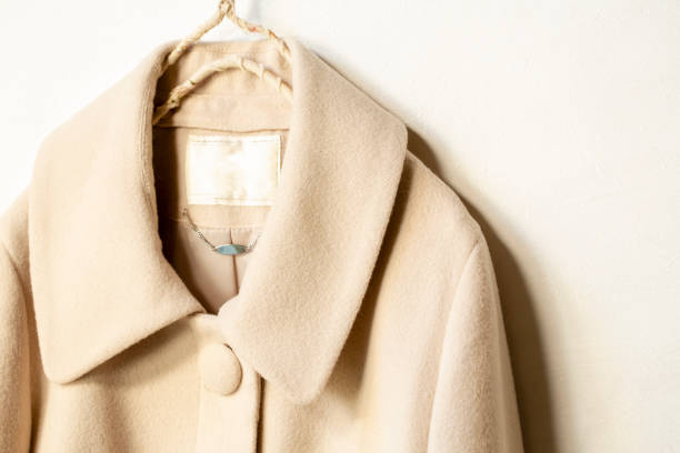 istock beige wool coat hanging on clothes hanger on white background 1157879610