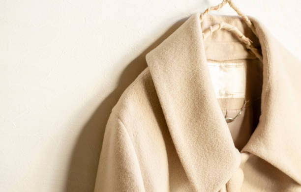 istock beige wool coat hanging on clothes hanger on white background 1157880240