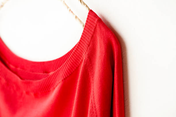 istock a cut sew or knit in red hanging on clothes hanger on white background. 1157880269