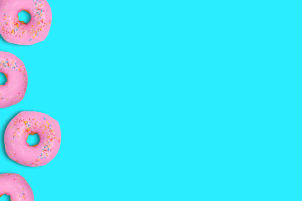 istock Flat lay sweet and colourful doughnuts on cyan soft pastel colour. Minimalistic background with copy space. 1157883403