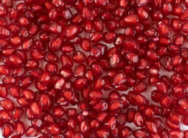 istock Scattered Pomegranate Seeds Texture on White Background 1157884347