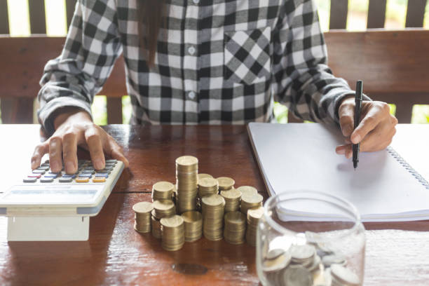 istock Businesswoman with calculator counting making notes, hand is writes in a notebook, Savings Account Money  Finance Concept, Finance concept 1157886262