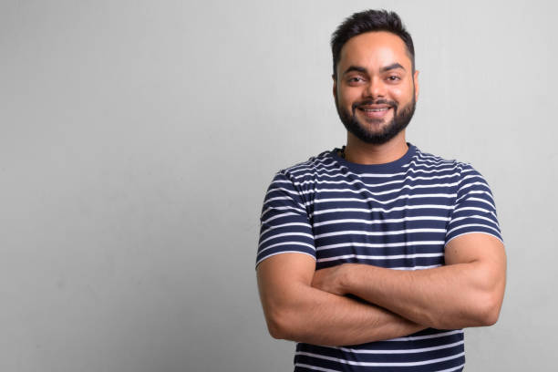 istock Young bearded Indian man against white background 1157889922