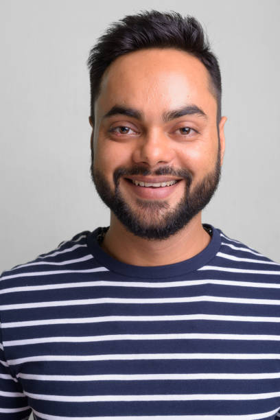 istock Young bearded Indian man against white background 1157889964
