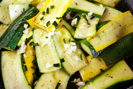 Freshly picked and chopped courgettes being gently fried with chopped garlic and chives.