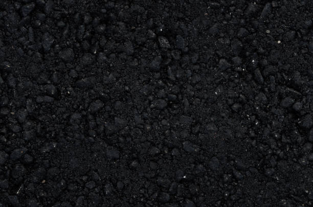 istock New black asphalt surface with large fractions. 1157892809