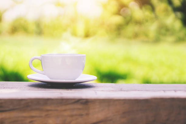자연 녹색 배경을 통해 나무 테이블에 뜨거운 커피 컵 - chocolate nobody water tea 뉴스 사진 이미지