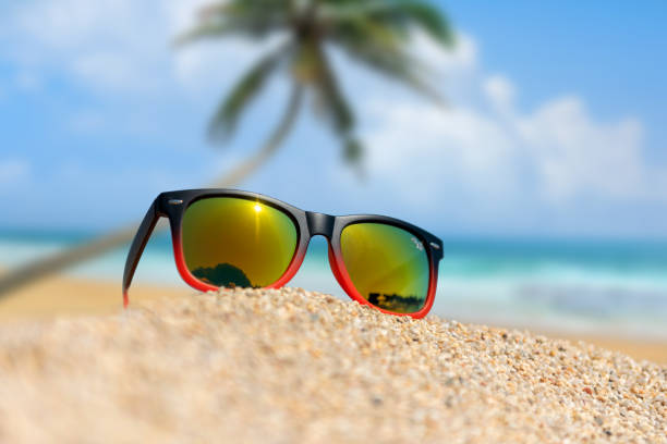istock Mirrored sunglasses close up on the beach sand 1157899070