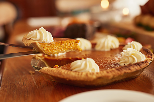 Cropped shot of an unrecognizable person serving pumpkin pie at a celebratory feast
