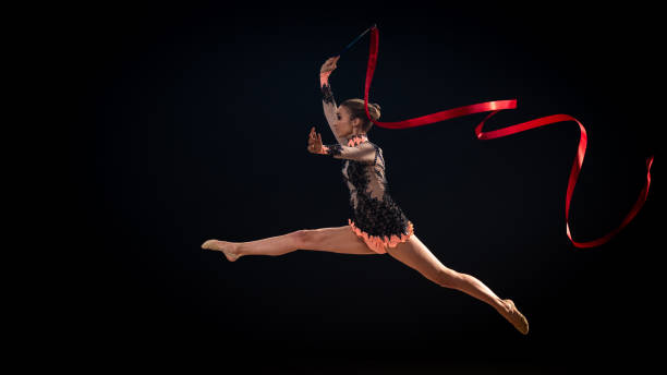 istock Gymnast doing rhythmic gymnastics with red ribbon 1157901658