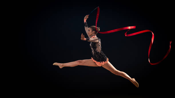 гимнастка делает художественной гимнастики с красной лентой - the splits фотографии стоковые фото и изображения