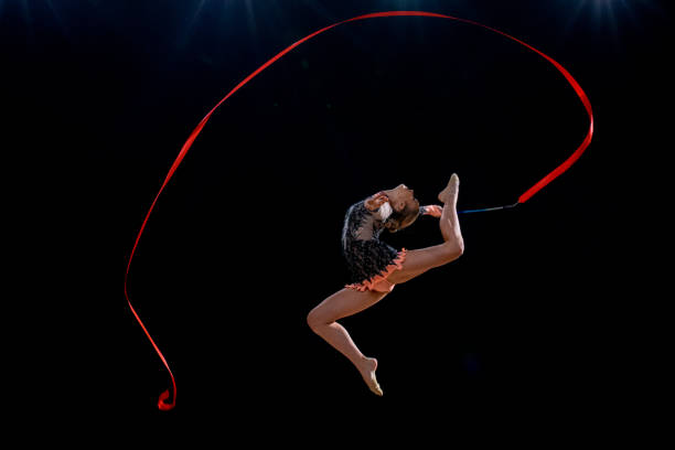 istock Gymnast doing rhythmic gymnastics with red ribbon 1157901659