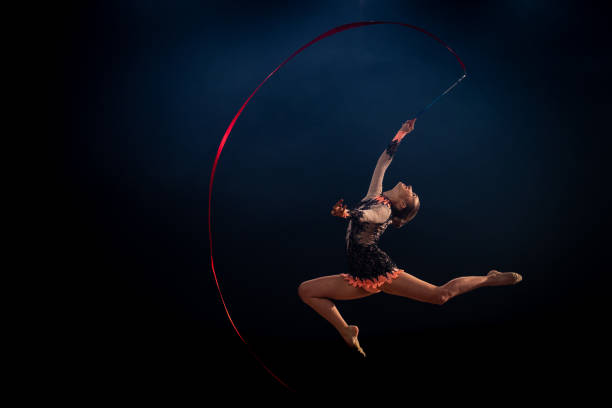 istock Gymnast doing rhythmic gymnastics with red ribbon 1157901660