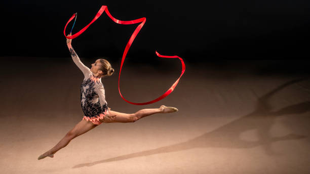 istock Gymnast doing rhythmic gymnastics with red ribbon 1157901668