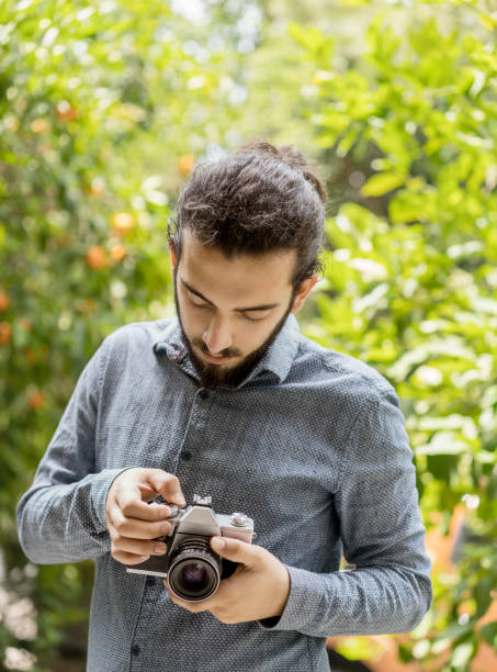 istock Man holding a vintage film camera 1157902555