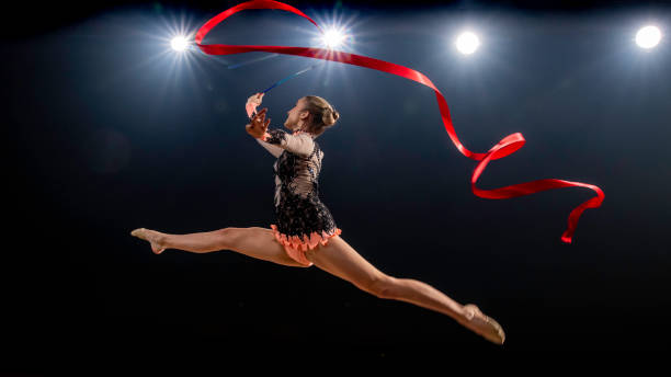 istock Gymnast doing rhythmic gymnastics with red ribbon 1157902577