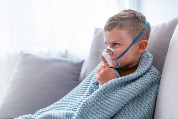Caucasian child holding oxygen or inhaler mask at home. Little boy having inhalation for easing cough. Caucasian blonde boy inhales couples containing medication to stop coughing. Medical procedures. Inhaler. Respiratory medicine. respiratory disease stock pictures, royalty-free photos & images