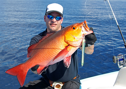 Catch of fish, big game fishing, Lucky  fisherman holding a red snapper fish