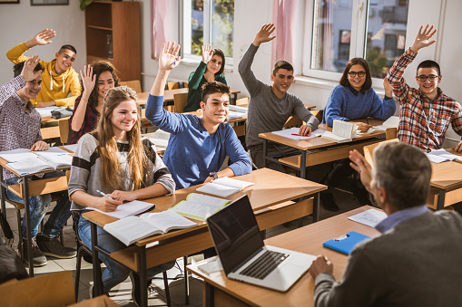 Happy High School Students Raising Their Hands On A Class Stock Photo -  Download Image Now - iStock