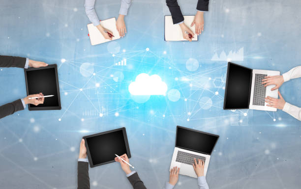 istock Group of people with devices in hands working on laptops and tablets with online teamwork concept 1157906123