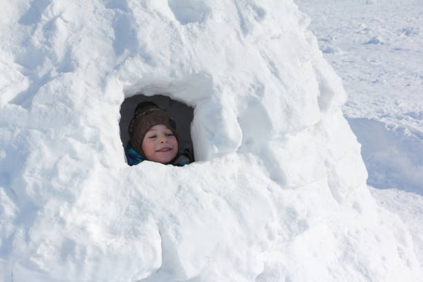 istock Happy cheerful boy sitting in an igloo in winter 1157908317