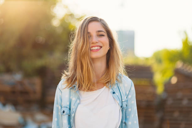 istock Gorgeous girl with a beautiful smile and sunrays reflected on her happy face 1157912459