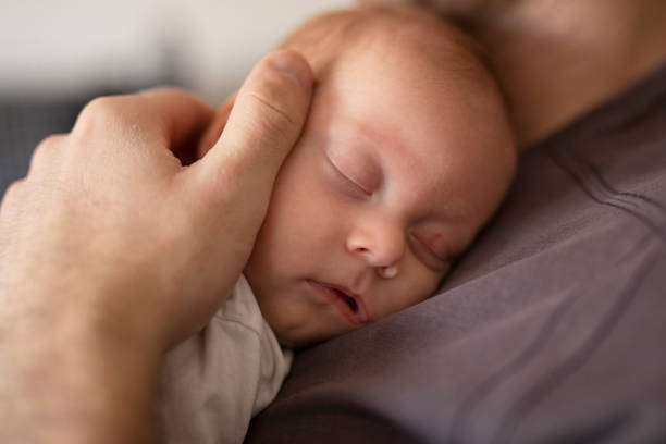 istock Father putting his baby to sleep 1157912924