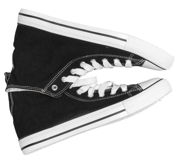 Close-up of a pair of black and white sneakers featuring a simple yet stylish lace-up design. The shoes are positioned to highlight their classic silhouette and contrasting rubber soles, making them versatile for everyday wear or informal outings.