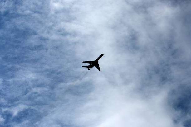 istock the plane flies across the blue sky 1157915981