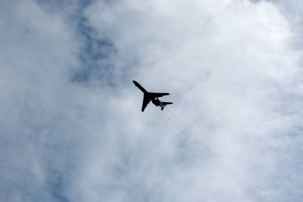 istock the plane flies across the blue sky 1157915982