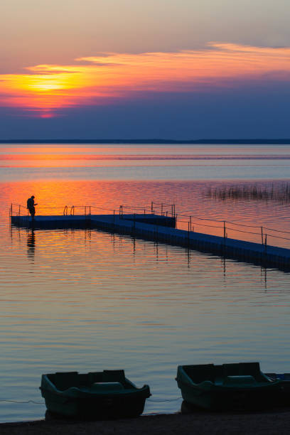 istock men on pontoon pier at sunset 1157918564