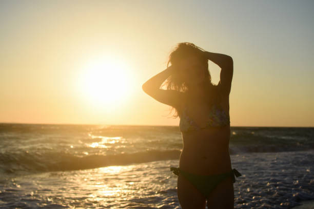 istock Woman on the beach relax at sunset 1157919933