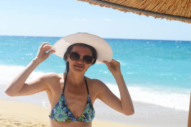 istock Woman with a hat enjoy at beach 1157920392