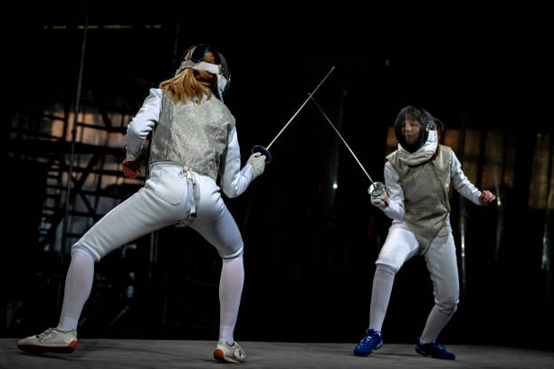 athlètes d'escrimeur concourant pendant les jeux olympiques - fencing sport athlete sword photos et images de collection