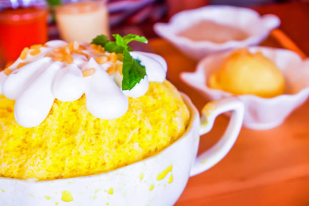 istock Bingsu (Korean dessert style) refreshing dessert served with mango fruit sticky rice, ice cream and sweetened condensed milk on the wooden plate. 1157921482
