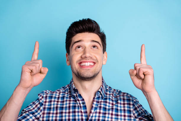 istock Close up photo amazing he him his macho wondered indicate look up empty space both index fingers tips feedback advising buy buyer wear casual checkered plaid shirt isolated bright blue background 1157924468