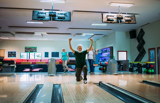 Group of seniors having fun bowling.