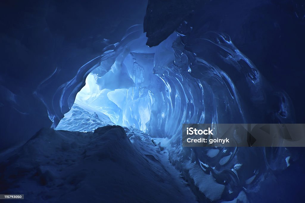 Beautiful blue ice cave with entrance visible blue ice cave covered with snow and flooded with light Glacier Stock Photo