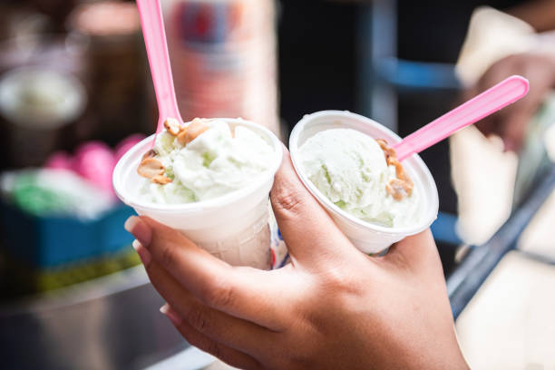 istock Coconut ice cream with peanuts in woman’s hand 1157931419
