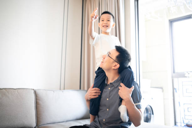 istock Asian father carrying his son on his shoulders 1157933276
