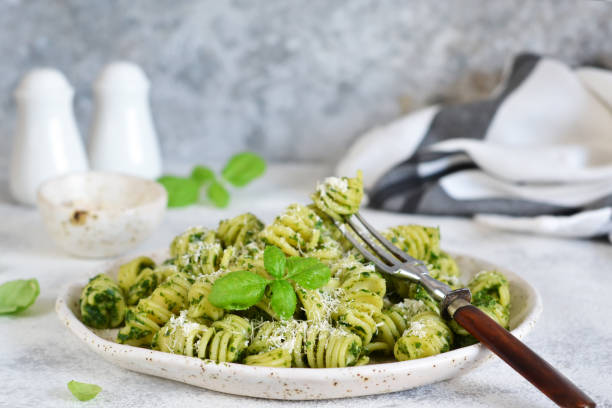 istock Vegan pasta with spinach, basil and parmesan. Lunch on the kitchen table. 1157939508