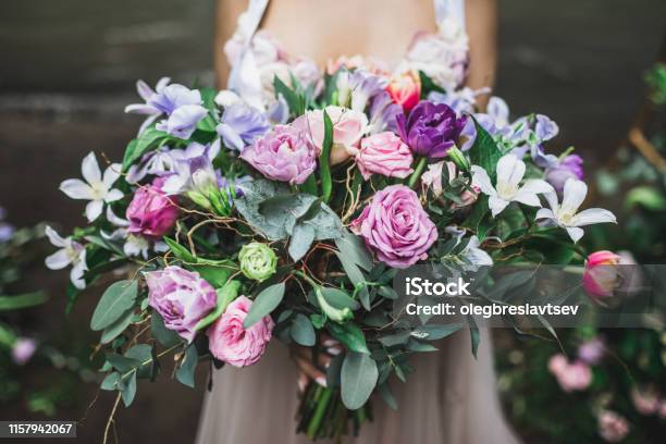 Bride Holding B Beautiful Colorful Wedding Bouquet Of Roses Peonies And Tulips In Bright Pink Coral And Purple Colors Stock Photo - Download Image Now