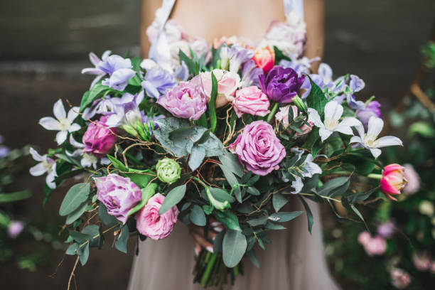 noiva que prende b ramalhete colorido bonito do casamento das rosas, dos peônias e dos tulips em cores cor-de-rosa, corais e roxas brilhantes. - flower arrangement fotos - fotografias e filmes do acervo