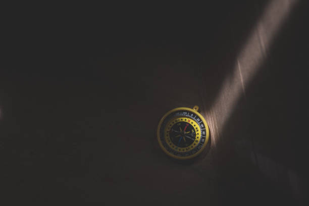istock Compass on the dark wood surface with a light spot 1157942207