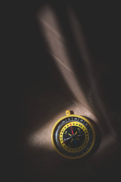 istock Compass on the dark wood surface with a light spot 1157942220