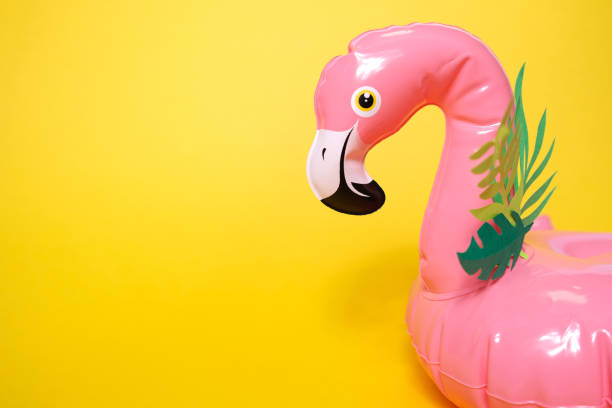 istock Inflatable pink flamingos on a bright yellow background. 1157942611