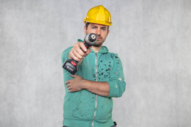 the construction worker holds an electric screwdriver in his hand, various situations